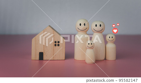 Happy house concept. Model house with wooden dolls standing lined up on pink background and heart icons. Indicates happiness and love in the home. Happy house concept. Model house with wooden dolls standing lined up on pink background and heart icons. Indicates happiness and love in the home. 95582147
