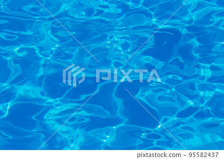 Swimming pool water surface with sparkling light reflections Swimming pool water surface with sparkling light reflections 95582437