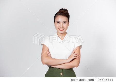 Smiling young beautiful Asian businesswoman doing arm crossed gestures in isolated studio white background Smiling young beautiful Asian businesswoman doing arm crossed gestures in isolated studio white background 95583555