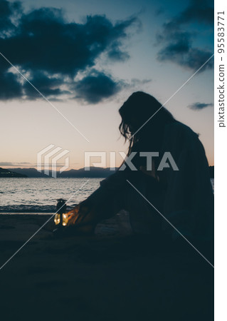 Silhouette photo of a woman standing on the beach Silhouette photo of a woman standing on the beach 95583771