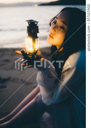 Photo of a woman standing by the beach Photo of a woman standing by the beach 95583908