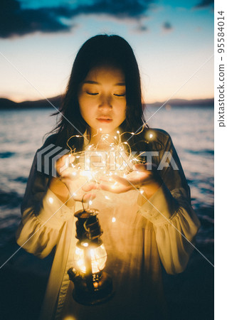 Photo of a woman standing by the beach 95584014