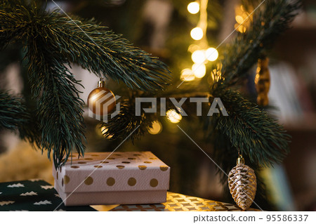 Beautiful green Christmas tree decorated with balls and garlands. 95586337