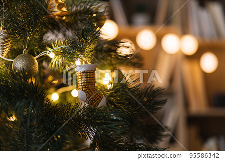 Golden Christmas tree toys on green branches of a Christmas tree. Golden Christmas tree toys on green branches of a Christmas tree. 95586342