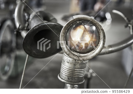 Lamp with shattered glass on handlebars of antique bicycle 95586429