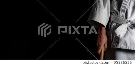 A person practicing aikido on a black background. 95586536