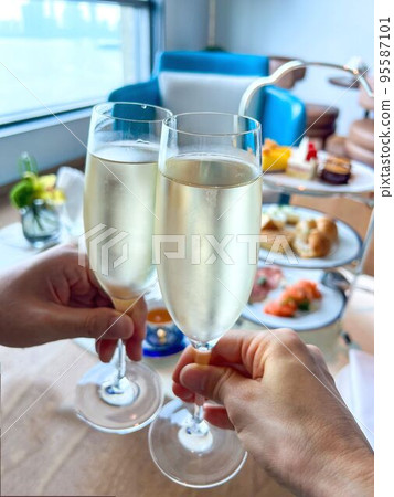 拿著香檳酒杯和下午茶的手 拿著香檳酒杯和下午茶的手 95587101