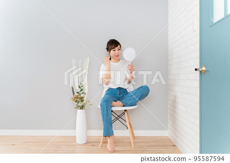 Asian woman looking at the mirror at home and checking her hair (hair set) Asian woman looking at the mirror at home and checking her hair (hair set) 95587594