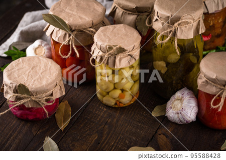 Pickled vegetables in glass jars. 95588428
