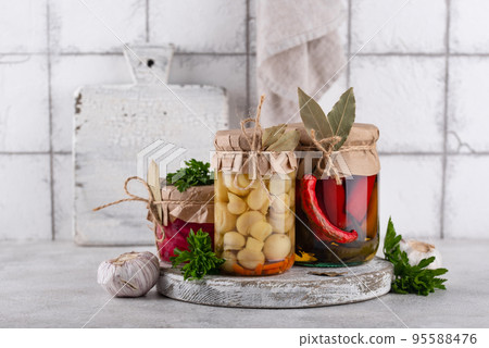Pickled vegetables in glass jars. 95588476