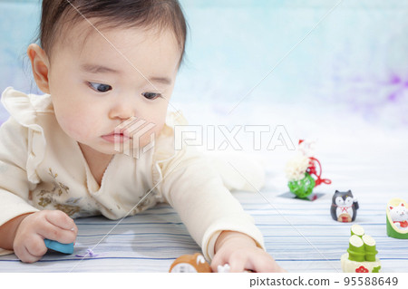 Baby girl wearing a dress and playing indoors 95588649