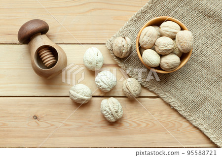 walnuts group top view on wooden table with nutcracker. Walnut kernels and whole walnuts 95588721