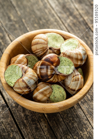 Snails with parsley butter, Bourgogne Escargot Snails in bowl. Delikatese food. 95589320