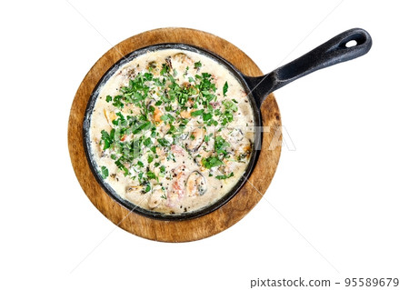Mussels in creamy sauce with parsley in hot frying pan on wooden stand. Tasty meal in sea restaurant attracts tourist attention to explore 95589679