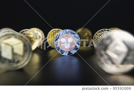 Ripple XRP next to many cryptocurrency coins like defocused Ethereum, Neo, Tether on black background. Central composition, low key photo for banners and news about crypto. Ripple XRP next to many cryptocurrency coins like defocused Ethereum, Neo, Tether on black background. Central composition, low key photo for banners and news about crypto. 95591009