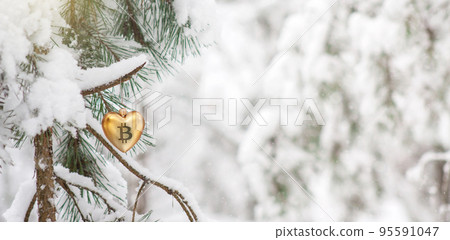 Bitcoin symbol on single gold heart shaped Christmas bauble hanging from a snow covered pine tree in forest with beautiful blurred background. Winter holiday crypto banner with copy space for text Bitcoin symbol on single gold heart shaped Christmas bauble hanging from a snow covered pine tree in forest with beautiful blurred background. Winter holiday crypto banner with copy space for text 95591047
