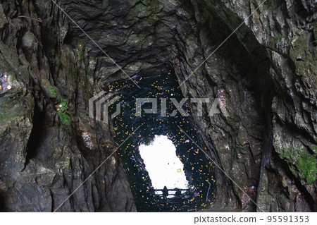 view of the sky through a deep granite underground well 95591353