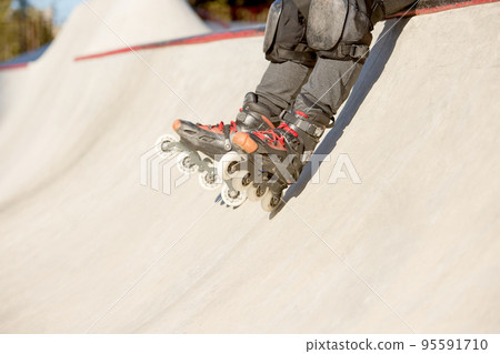 Man's legs in rollerblades. Leisure activities outdoors in autumn sunny day. Concept of active lifestyle, sport, hobbies. Man's legs in rollerblades. Leisure activities outdoors in autumn sunny day. Concept of active lifestyle, sport, hobbies. 95591710