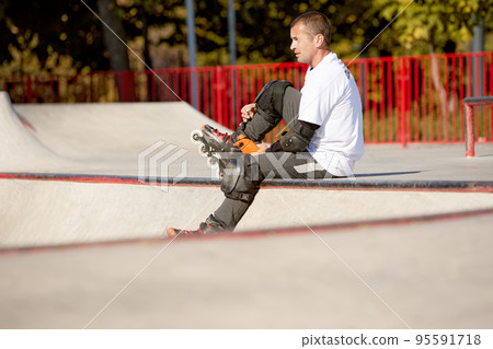 One man, male roller skater on rollerblades training at modern skate park, outdoors. Action, motion, skills and challenges. Doing different tricks One man, male roller skater on rollerblades training at modern skate park, outdoors. Action, motion, skills and challenges. Doing different tricks 95591718