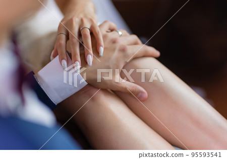 Man's hand gently holding woman's hand - closeup shot. 95593541