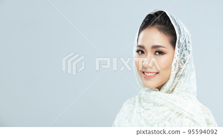 Face shot 20s Asian Woman has beautiful wedding clean face skin. Lace hijab cloth female feel happy smile fashion vintage poses over grey background isolated copy space 95594092