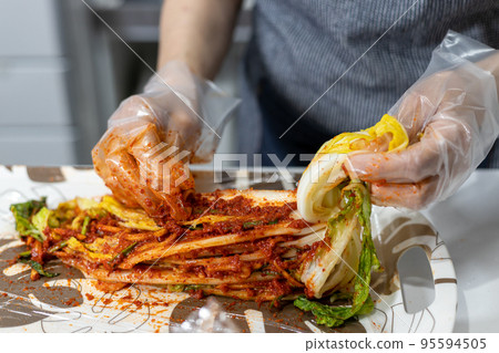 Making homemade Chinese cabbage kimchi in the kitchen at home 95594505