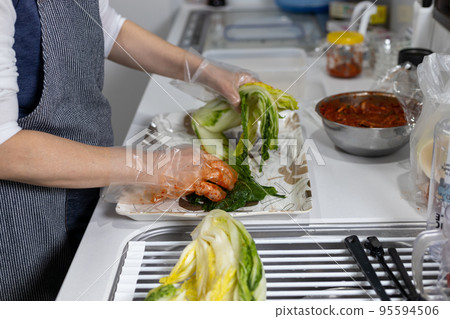 Making homemade Chinese cabbage kimchi in the kitchen at home 95594506