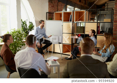 Group of young people, businessmen at business meeting at office space. Scientific conference event, training, brainstorm. 95594920