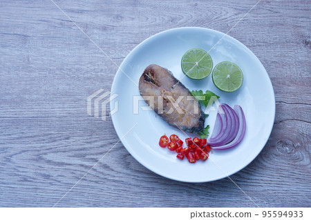 salty dry Indo-Pacific king mackerel fish topping chop shallot and chili with slice lemon salad on plate salty dry Indo-Pacific king mackerel fish topping chop shallot and chili with slice lemon salad on plate 95594933