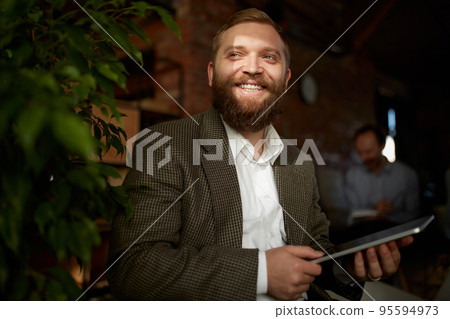 Happy smiling man in bussiness style costume looking at camera at working day in office room. Business, finance, professional occupation, ideas, plans 95594973