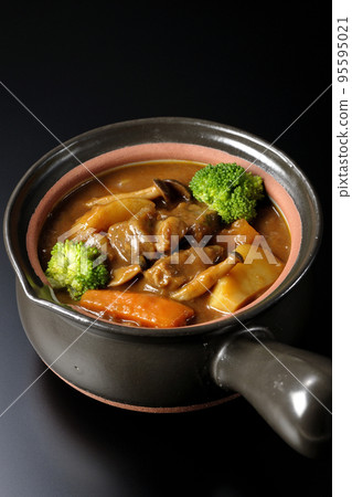 A beef stew with many ingredients such as broccoli, carrots, and shimeji mushrooms in a pot with a black background A beef stew with many ingredients such as broccoli, carrots, and shimeji mushrooms in a pot with a black background 95595021