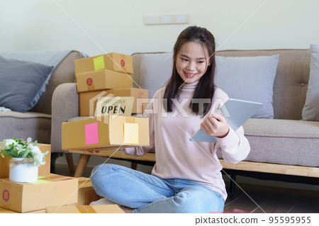 Portrait of Starting small businesses, Asian woman check online orders Selling products working with boxs freelance work at home office, sme business concepts Portrait of Starting small businesses, Asian woman check online orders Selling products working with boxs freelance work at home office, sme business concepts 95595955
