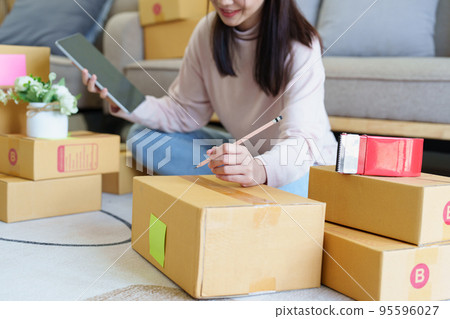 Portrait of Starting small businesses, Asian woman check online orders Selling products working with boxs freelance work at home office, sme business concepts Portrait of Starting small businesses, Asian woman check online orders Selling products working with boxs freelance work at home office, sme business concepts 95596027