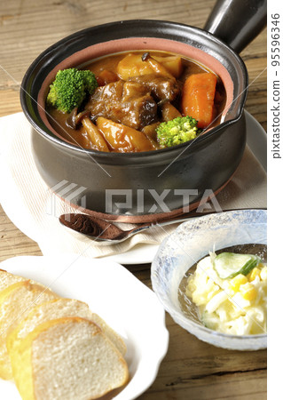 Beef stew, salad and bread with lots of ingredients such as broccoli, carrots, and shimeji mushrooms in a pot. 95596346
