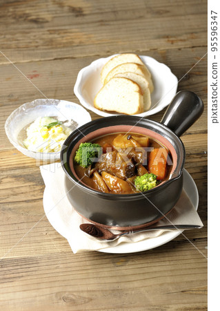 燉牛肉、沙拉和麵包,在鍋中加入大量食材,如西蘭花、胡蘿蔔和蘑菇。 燉牛肉、沙拉和麵包,在鍋中加入大量食材,如西蘭花、胡蘿蔔和蘑菇。 95596347