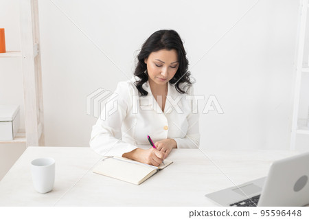 Indian woman beautician takes notes in office - cosmetologist business woman or doctor concept 95596448