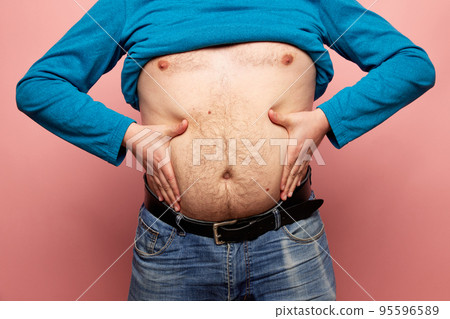 Cropped image of fat man showing his belly, abdomen. Close up part of man's body. Concept of dieting, sport, fitness, healthy lifestyle, body positive 95596589