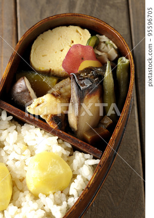 A bento box filled with autumn flavors such as chestnut rice and sweet potatoes in magewappa 95596705