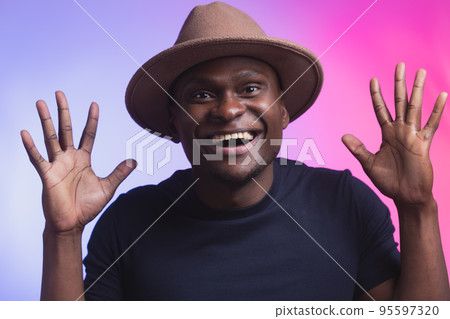 Overjoyed impressed african american man raise opened hands palms surprised wow happy emotions on pink and violet color background Overjoyed impressed african american man raise opened hands palms surprised wow happy emotions on pink and violet color background 95597320