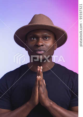 Praying african american man hoping for better. Asking God for good luck success forgiveness. Power of religion belief worship. Holding hands in prayer Praying african american man hoping for better. Asking God for good luck success forgiveness. Power of religion belief worship. Holding hands in prayer 95597321