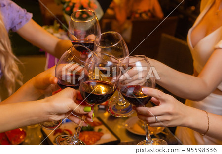 Clinking glasses with alcohol and toasting, party. 95598336