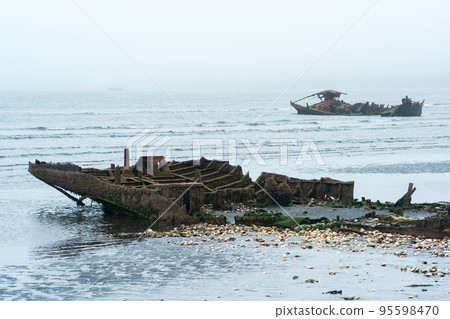 remains of a wrecked ship on a foggy seashore remains of a wrecked ship on a foggy seashore 95598470