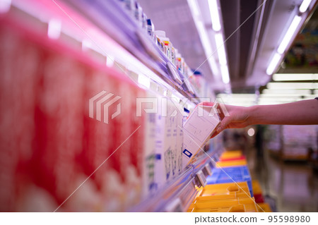 Woman's hand buying milk in supermarket 95598980