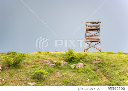 A wooden watchtower in the farm field. 95599200