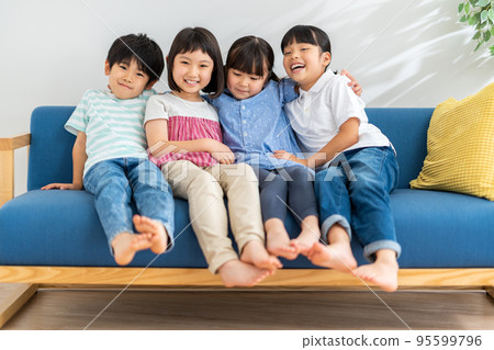 Elementary school students sitting together on the sofa 95599796