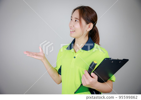 穿著工作服的日本女人拿著文件（有字母空間） 95599862