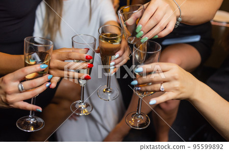 Clinking glasses with alcohol and toasting, party. 95599892