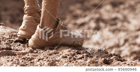 Mud race runner very muddy running shoes, muddy feet detail 95600946