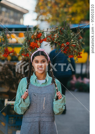 Playful farmer woman in denim overalls smiling sincerely while posing. Playful farmer woman in denim overalls smiling sincerely while posing. 95601010