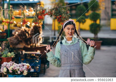 Playful farmer woman in denim overalls smiling sincerely while posing. Playful farmer woman in denim overalls smiling sincerely while posing. 95601063